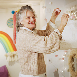 Lisa smiling while hanging an art project